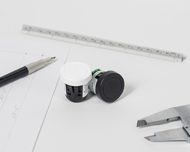 Small Lutron lighting control modules shown next to ruler and pen for size perspective.