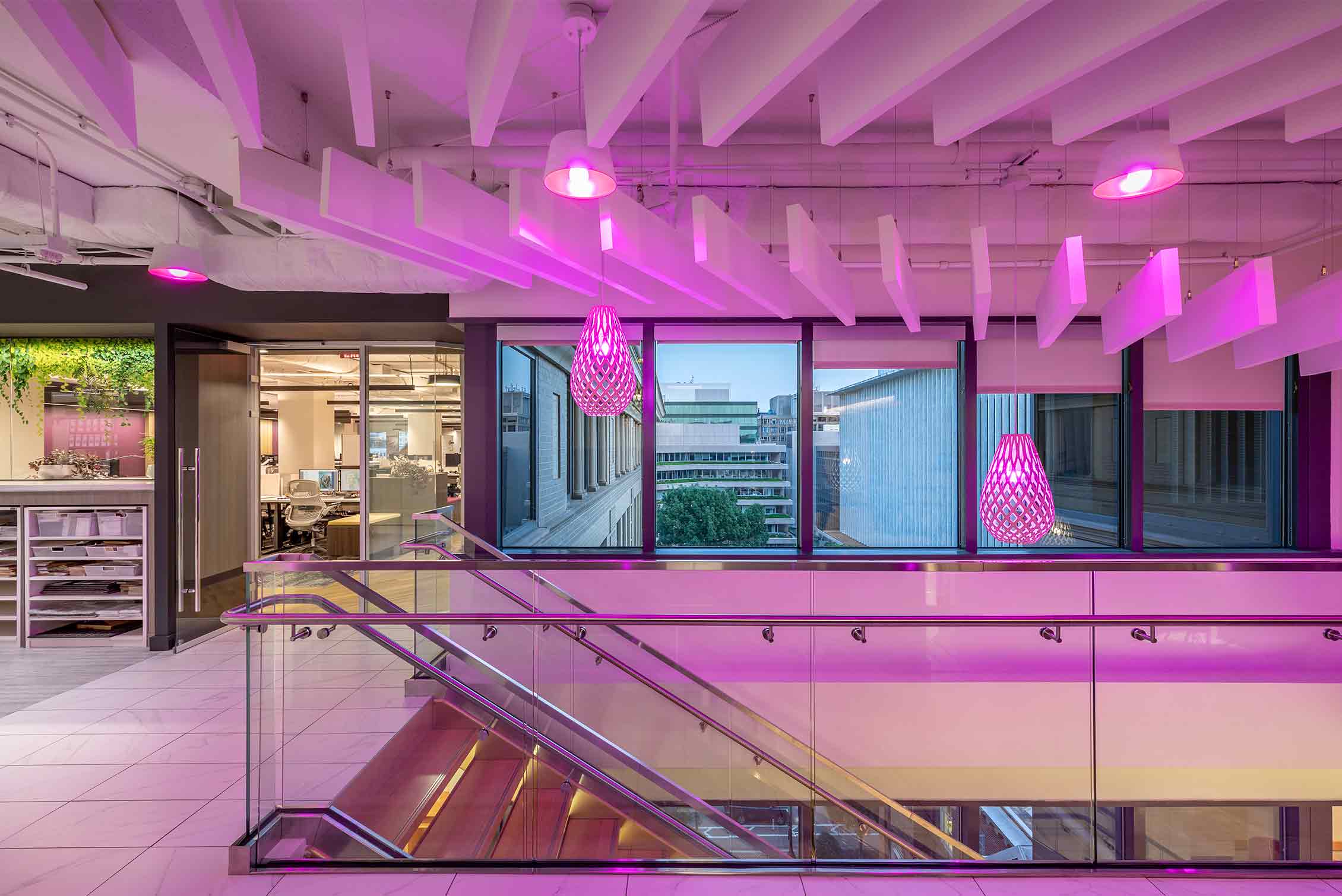 Magenta light glows in a Ketra Ready pendant over the stairs in Page's D.C. office