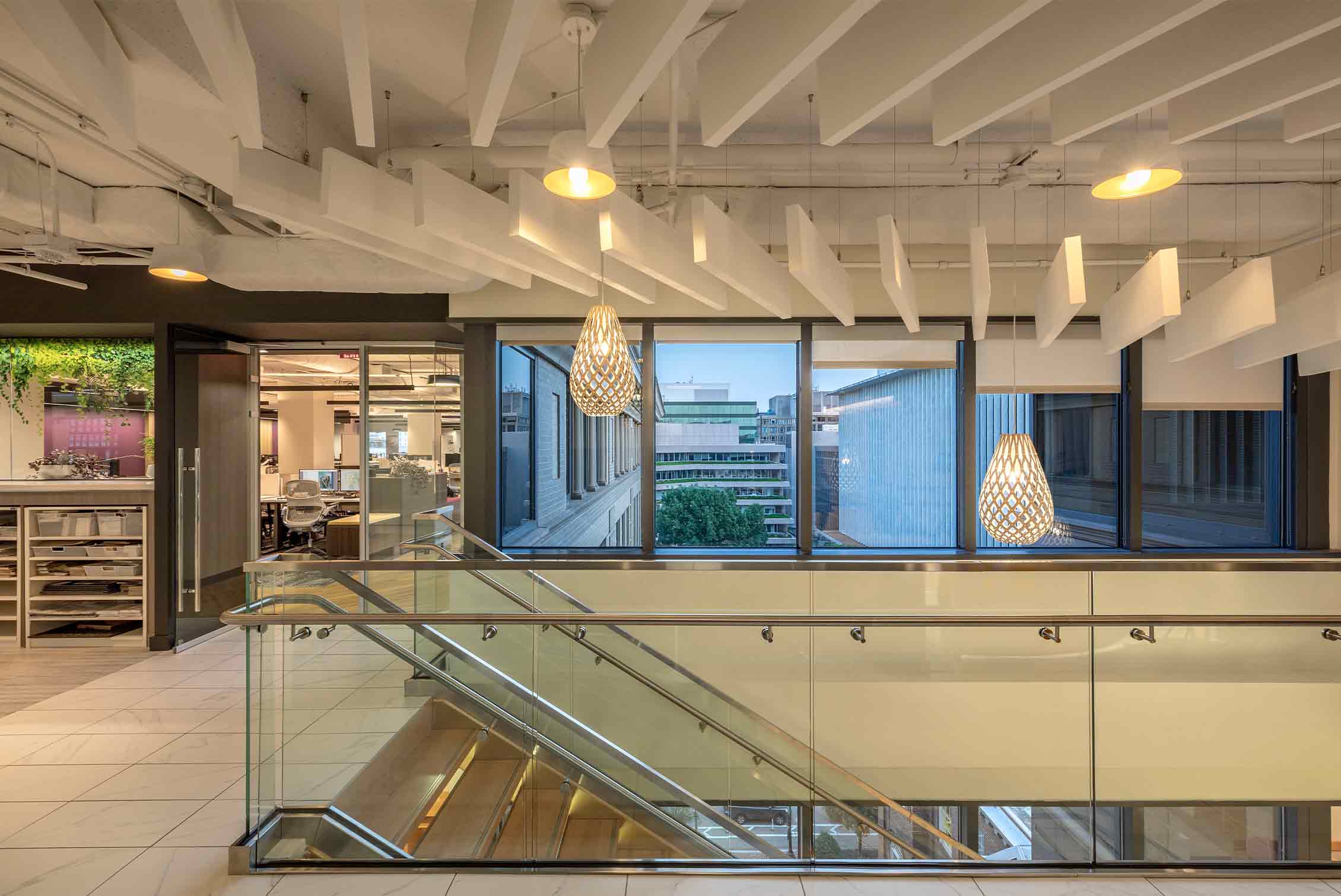 Warm white light glows in a Ketra Ready pendant over the stairs in Page's D.C. office