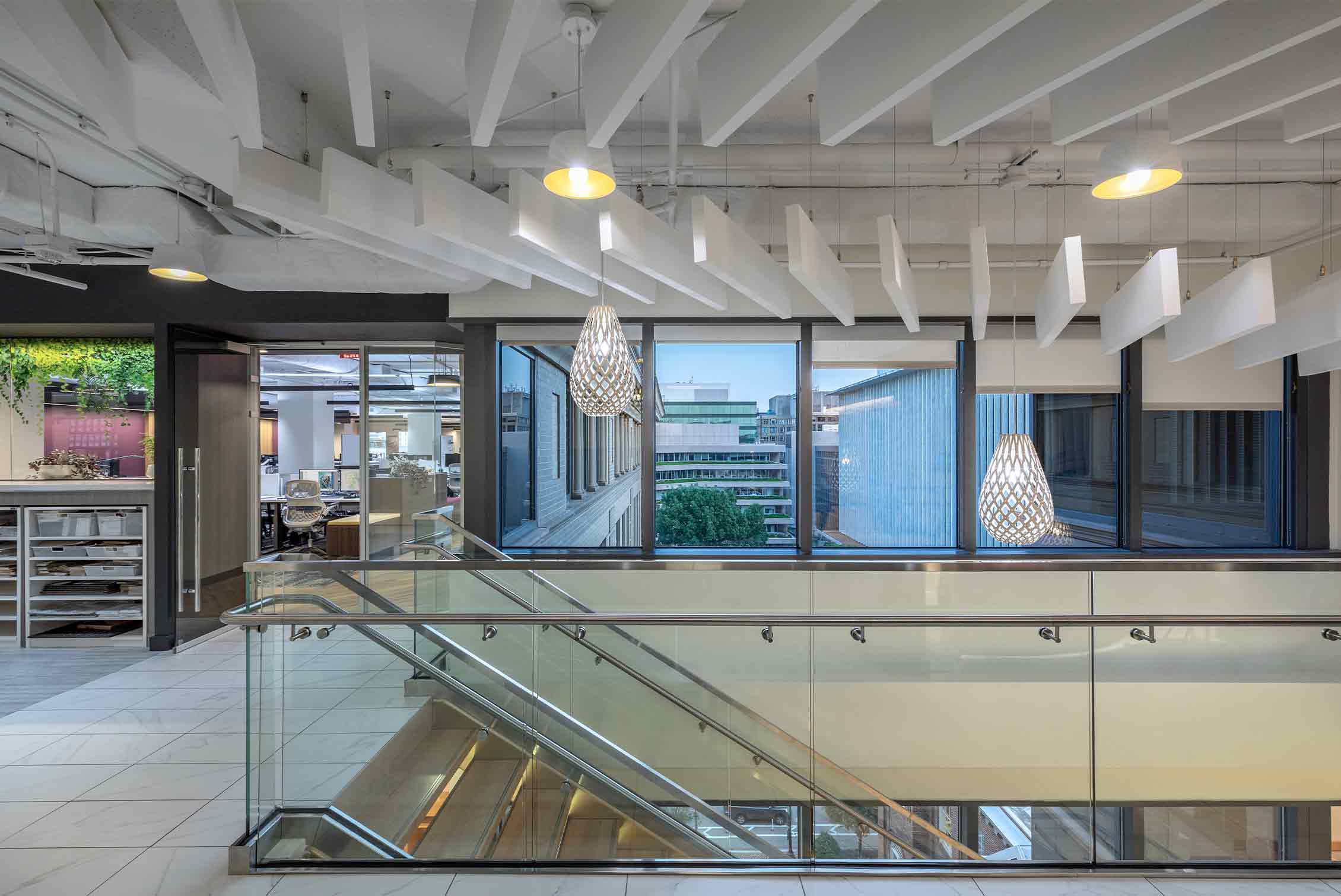 Cool white light glows in a Ketra Ready pendant over the stairs in Page's D.C. office