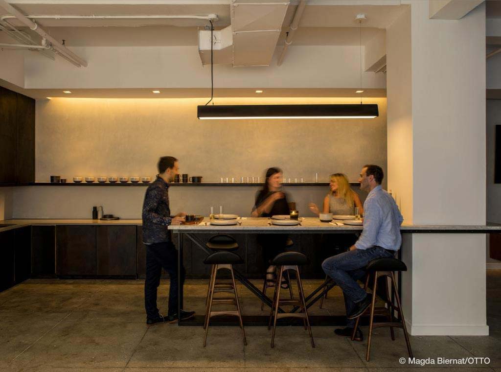 group of people in office kitchen with warm lighting