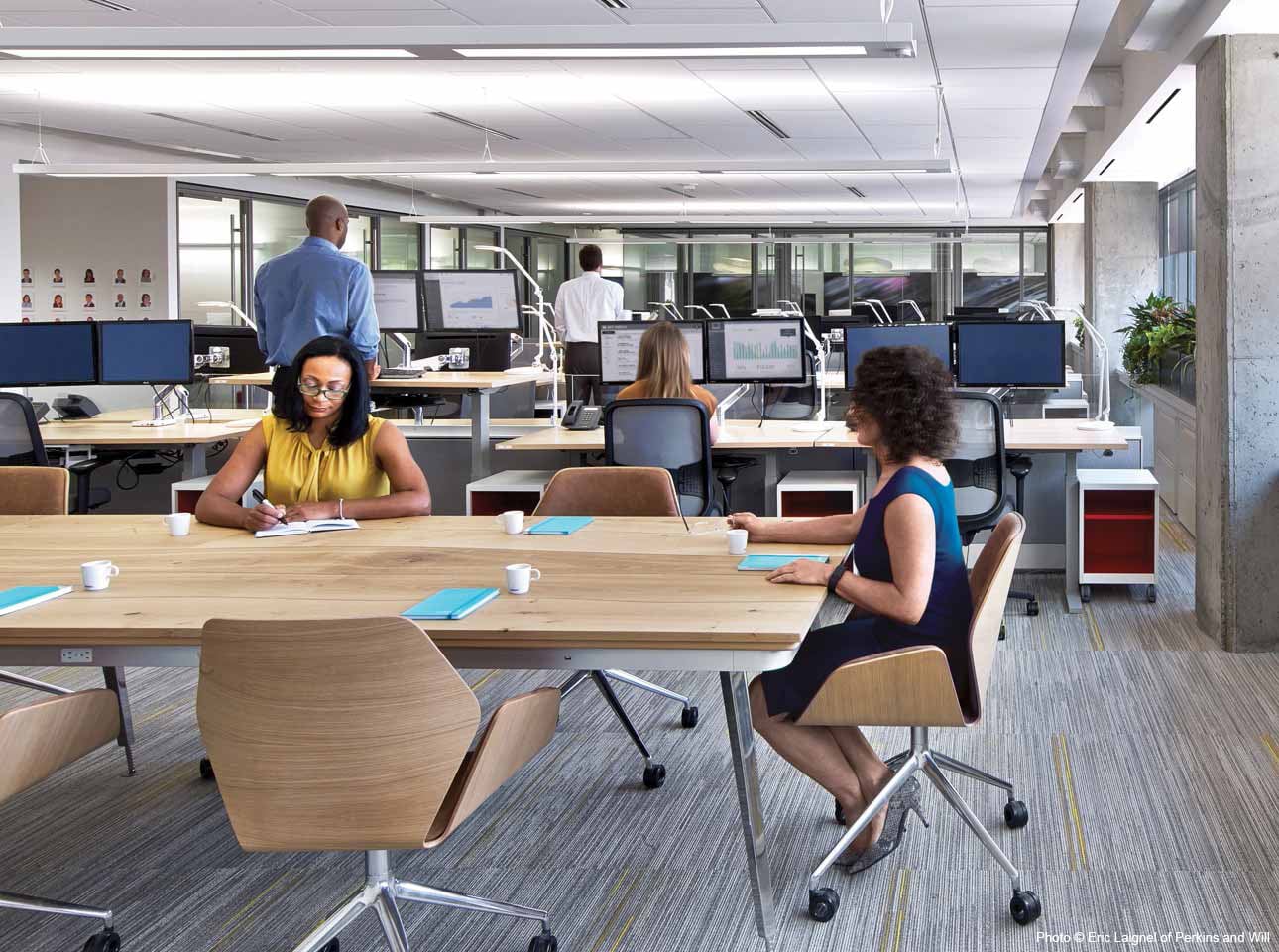 two women sitting at a desk in an office